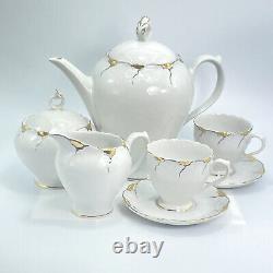Service à thé en porcelaine VTG Korosten avec cafetière, tasses, soucoupes, sucrier et crémier, bordure dorée.